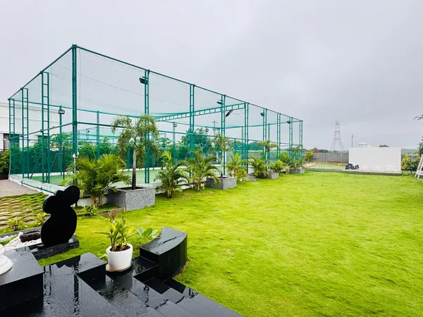 Panoramic lawn and cricket nets at Green Haven Sports Farm Villa near Hyderabad